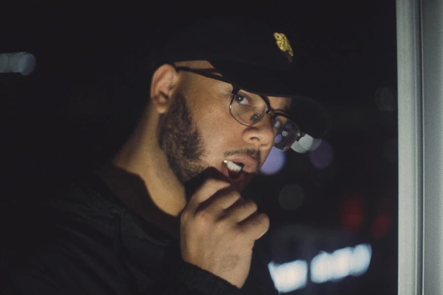 16os in a black cap and glasses at night